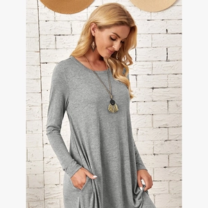 Detail of grey loose-fit knit dress featuring side pockets and curved hem design