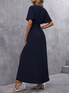 Détail d'une robe longue bleu marine avec taille élastiquée et fente latérale haute
