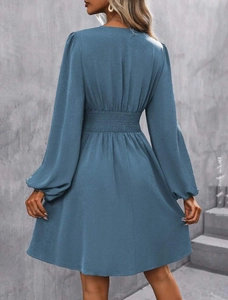 Detailed back view of a smocked waist dress with lantern sleeves in dusty blue fabric