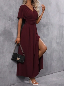 Détail de la robe cache-cœur bordeaux à col en V avec plis à la taille et fente haute sexy