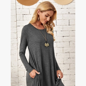 Detail of dark grey knit long sleeve dress with side pockets and curved hemline