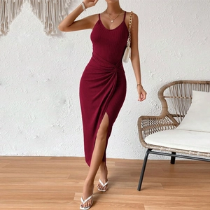 Détail d'une robe en maille bordeaux avec nœud à la taille et fente latérale élégante