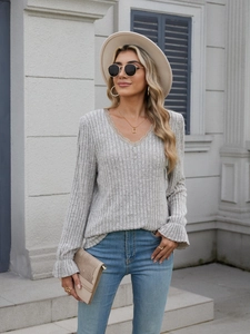 Detail of grey ribbed knit V-neck shirt with beige lace trim and flared sleeve cuffs