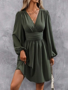 Detailed close-up of high-waist pleated midsection on this dark green V-neck dress