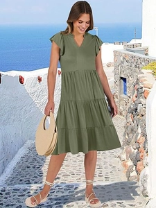 Abito midi a balze verde militare con scollo a V e maniche a volant in ambiente marittimo