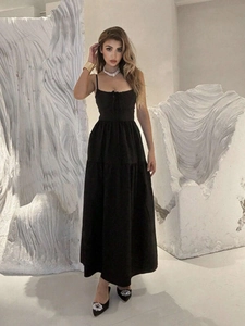 Detailed view of the black halter maxi dress with delicate bow and high waist