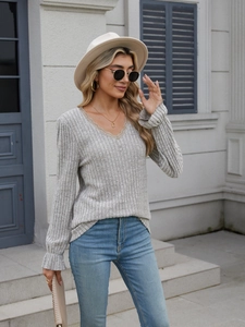 Close-up of light gray ribbed knit top with V-neck and delicate lace trimming