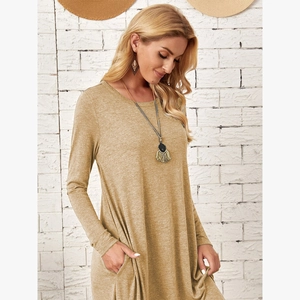 Detail view of the soft knit fabric texture and side pockets on a loose long sleeve dress