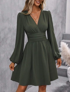 Detail of elegant V-neck wrap dress with lantern sleeves and pleated waist in dark green