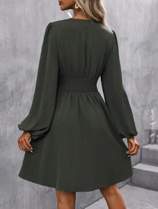 Detail of smocked elastic waist and long puff sleeves on dark green maxi dress