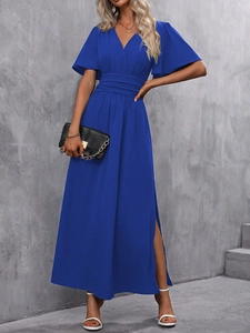 Détail d'une robe longue bleu roi avec col en V, manches volantées et fente latérale