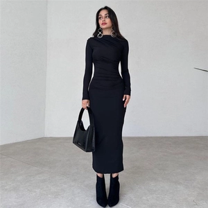 Détail du design plissé à la taille sur une robe maxi moulante noire à manches longues