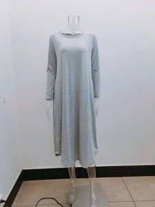 Detail of grey knit long sleeve dress with curved hem and side pockets in loose fit