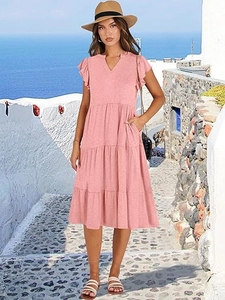 Dettaglio dell'abito rosa con scollo a V, balze e tasche laterali per le vacanze