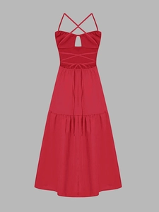 Close-up of red halter dress featuring a cross back design and tiered A-line skirt detail