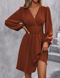Detail of V-neck wrap dress with lantern sleeves and cinched waist in caramel brown