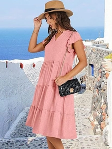 Abito midi rosa con scollo a V e maniche a balze in una cornice estiva costiera