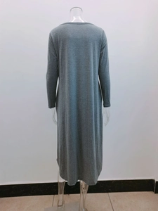 Rear view of a grey loose knit midi dress with a curved hem and functional side pockets