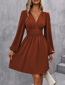 Detail of caramel V-neck dress showing high waist pleats and elegant lantern sleeves
