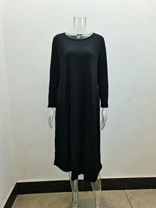 Detail view of smooth black knitted fabric and side seam pocket on long sleeve dress