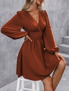 Detail view of the deep V-neck and ruched waist on a rust red lantern sleeve dress