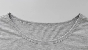 Close-up of crew neckline with double-needle stitching on grey knit dress fabric