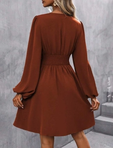 Rear view detail of terracotta long sleeve dress showing elastic waist and lantern sleeves