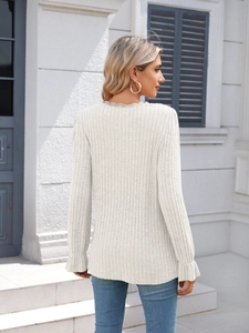 Detail of ribbed knit texture with delicate lace trim and ruffle cuffs on cream top