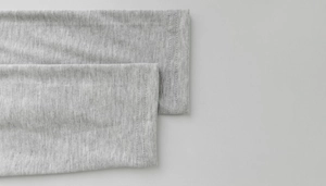 Detailed close-up of light grey heather knit dress sleeve with double-needle stitching