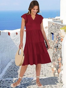Dettaglio dell'abito bordeaux con scollo a V e gonna a balze per donna elegante