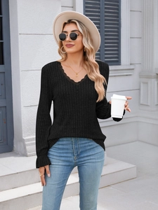 Detailed view of the V-neck with black lace trim and ribbed texture on the long sleeve top