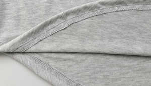Close-up of heather grey knitted dress with high-quality overlock stitching at the curved hem