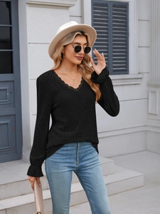 Detail of V-neck with lace trim and ribbed texture on this elegant black slim fit top