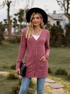 Close-up of ribbed knit texture and amber buttons on rose pink long cardigan