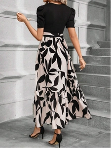 Detailed view of the pleated floral skirt and cinched waist on this summer dress