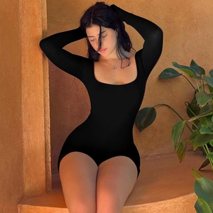 Close-up of deep U-neck and tie-back detail on slim fit black long sleeve yoga bodysuit