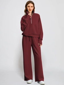 Women's burgundy two-piece tracksuit featuring half-zip hoodie and wide-leg sweatpants