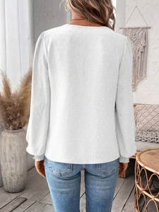 Rear view of women's white Swiss dot long sleeve blouse with elegant textured details