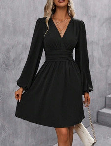 Detail view of deep V-neck and ruched high waist on a black long sleeve lantern dress