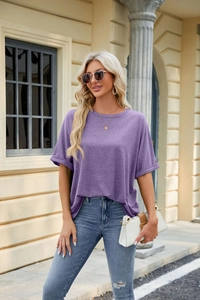 Detail view of purple T-shirt with folded sleeve cuffs and classic round neck on a model