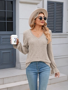 Detail of V-neck ribbed knit top with lace trim and ruffled cuffs for women