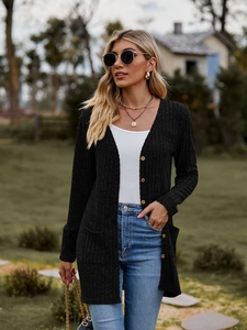 Detail of black ribbed knit cardigan featuring wooden buttons and practical side pockets