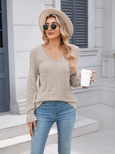 Detail of V-neck ribbed knit top with delicate lace trim and ruffled cuffs in beige