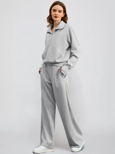 Close-up of light grey knit fabric on two-piece half-zip sweatshirt and wide-leg joggers