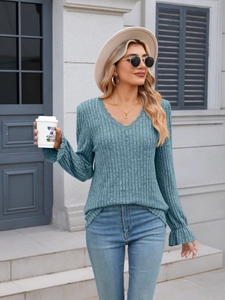 Detail of V-neck ribbed long sleeve top with lace trim and flaring ruffle cuffs in blue