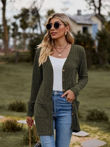 Detail of olive green ribbed knit cardigan featuring wooden buttons and front pockets