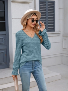 Detail of light blue ribbed knit top with V-neck lace trim and ruffled cuffs in street view