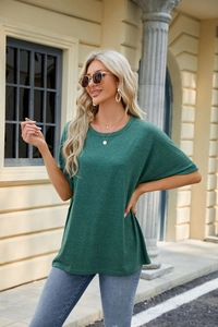 Detailed close-up of dark green loose fit t-shirt fabric and crew neck stitching