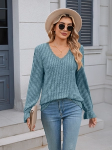 Detail of teal ribbed knit top featuring delicate lace V-neck and ruffled sleeve cuffs