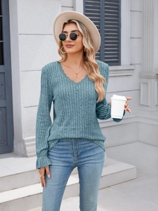 Close-up detail of blue V-neck ribbed knit top with delicate lace trim and ruffles